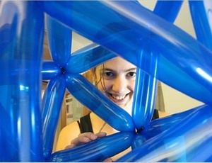 A matemusicista Vi Hart posa com uma figura geométrica montada com balões