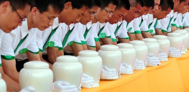 Funcionários depositam urnas biodegradáveis em cemitério de Tianjin, na China - AFP/Frederic J. Brown